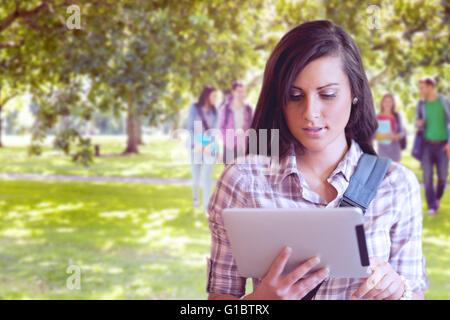 Immagine composita del giovane studente concentrato usando un computer tablet Foto Stock