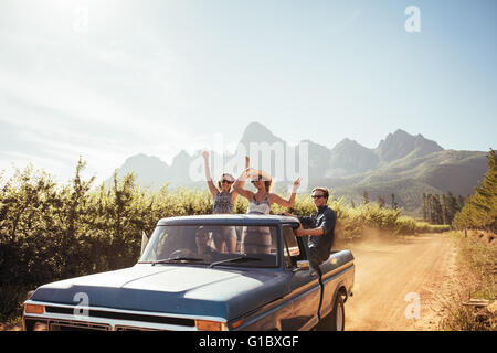 Un gruppo di giovani amici di equitazione a pickup truck divertirsi sul giorno di estate Foto Stock