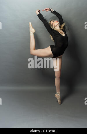 Bellissima ballerina facendo un arabesco Foto Stock