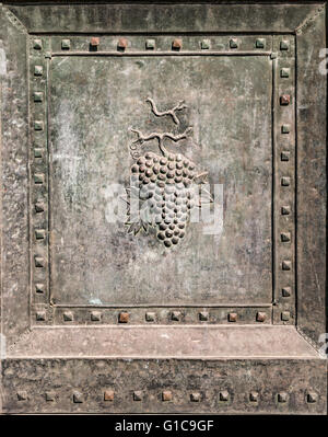 Grappolo di uva in rilievo in un antico portone di bronzo. Foto Stock