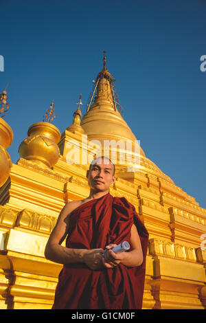 Uno dei monaci che frequentano le preghiere del pomeriggio presso la Pagoda Kuthodaw in Mandalay Foto Stock