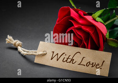 Con amore la parola su riciclare carta marrone con Red Rose su nero. Foto Stock