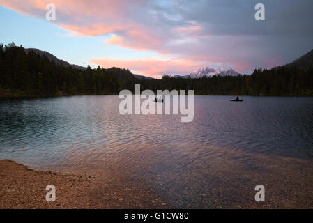 I pescatori sulle barche sul lago Hintersee in una piovosa, colorato tramonto, Berchtesgaden, Baviera, Germania Foto Stock