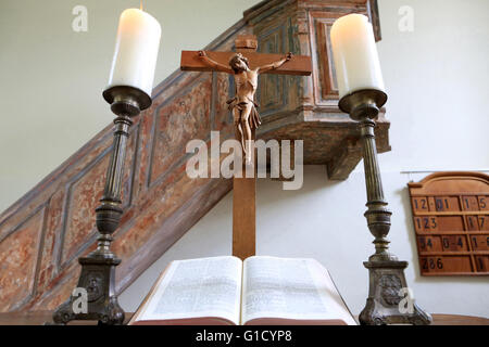 Crocifisso, candele e la Bibbia. Tempio luterano. Obersteinbach. La Francia. Foto Stock