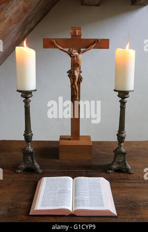 Candele, Crocifisso e la Bibbia. Tempio luterano. Obersteinbach. La Francia. Foto Stock