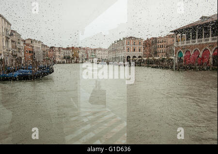 Venezia sotto la pioggia, attraverso il vetro in corrispondenza di una fermata del vaporetto Foto Stock