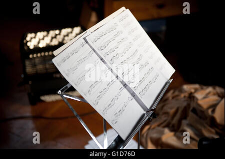 Foglio note musicali nel supporto rack in metallo con pagine in piedi in interni, carta stampata la notazione strumentale per l' esercizio Foto Stock