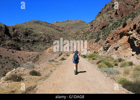 Donna camminando lungo il sentiero costiero nel Parco Nazionale Cabo de Gata, nei pressi di San José, Almeria, Spagna Foto Stock