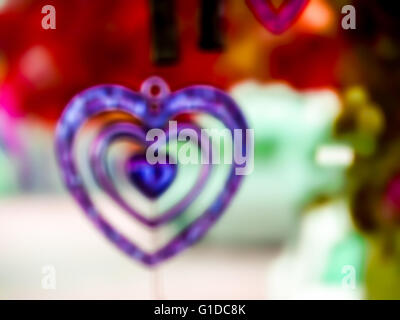 Cuore una decorazione mobili fatta di piccoli oggetti legati ai fili o stringa e appeso in modo che gli oggetti si muovono quando soffia aria aro Foto Stock