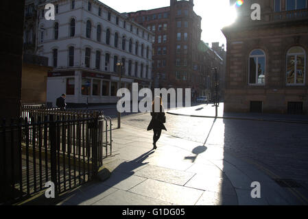 Silhouette di donna giovane sulla strada di Glasgow con road contre-jour mi retroilluminato a Glasgow, Scotland, Regno Unito. Foto Stock