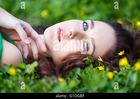 Donna attraente giacente in erba verde Foto Stock