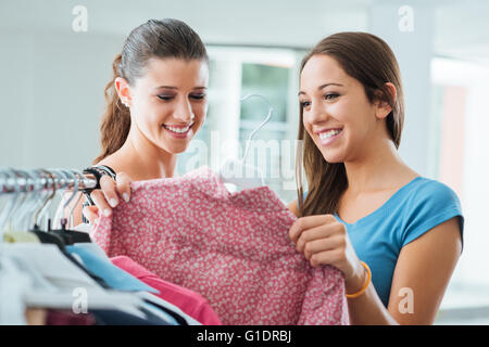 Carino young teen fidanzate shopping presso il negozio e godendo di uno è in possesso di una camicia Foto Stock