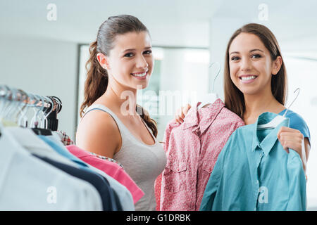 Gli adolescenti shopping abbigliamento donna presso il negozio e sorridente alla fotocamera, la soddisfazione del cliente e il concetto di qualità Foto Stock