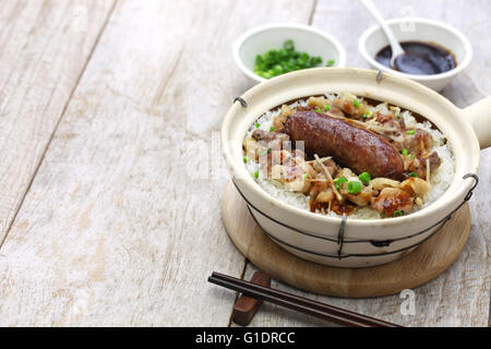 Di salsiccia cinese e di pollo con riso in pentola di creta, cibo cantonese Foto Stock