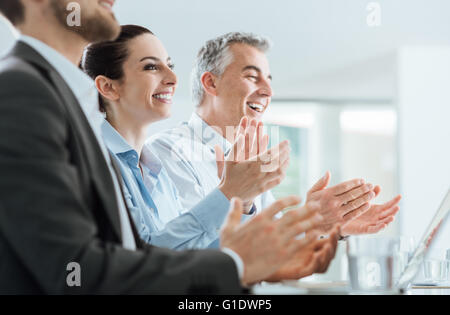 Allegro sorridente la gente di affari battendo le mani durante un seminario, il successo e il raggiungimento concept Foto Stock