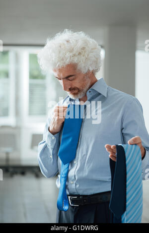 Imprenditore tenendo un sacco di cravatte, vestito color matching maschio ed un concetto di moda Foto Stock