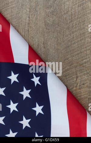 Frammento della bandiera americana ripiegata su legno tavolo in legno di noce. L'immagine verticale con copia spazio. Foto Stock