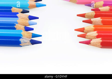 Matite colorate di diverse sfumature di colore rosso e blu con spazio di copia si trovano una contro l'altra lungo i bordi dell'immagine. Foto Stock