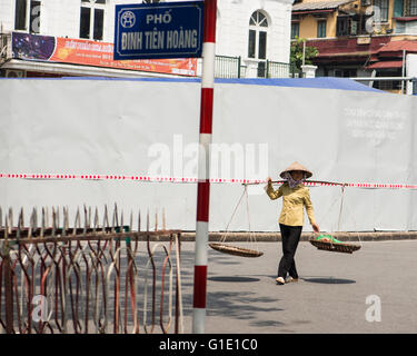 Donna vietnamita che porta frutto in cesti, Old Hanoi Foto Stock