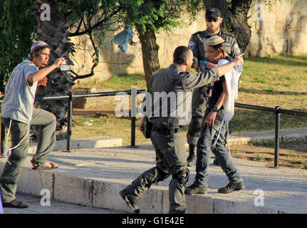 Gerusalemme, Gerusalemme, Territorio palestinese. Il 12 maggio 2016. Un membro delle forze di sicurezza israeliane sostiene di fronte a coloni ebrei nella parte anteriore della porta di Damasco, un ingresso principale a Gerusalemme la città vecchia a Maggio 12, 2016 © Mahfouz Abu Turk/immagini APA/ZUMA filo/Alamy Live News Foto Stock