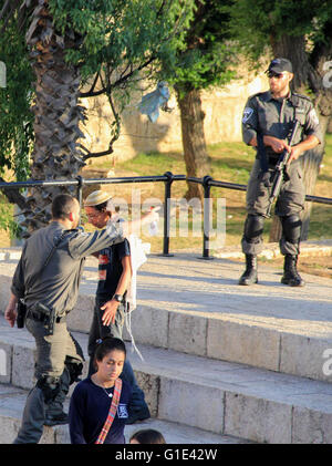 Gerusalemme, Gerusalemme, Territorio palestinese. Il 12 maggio 2016. Un membro delle forze di sicurezza israeliane sostiene di fronte a coloni ebrei nella parte anteriore della porta di Damasco, un ingresso principale a Gerusalemme la città vecchia a Maggio 12, 2016 © Mahfouz Abu Turk/immagini APA/ZUMA filo/Alamy Live News Foto Stock