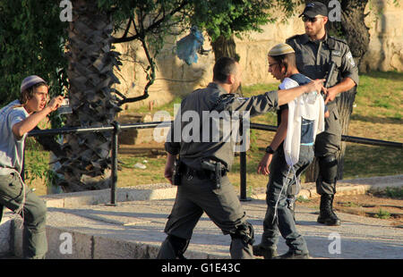 Gerusalemme, Gerusalemme, Territorio palestinese. Il 12 maggio 2016. Un membro delle forze di sicurezza israeliane sostiene di fronte a coloni ebrei nella parte anteriore della porta di Damasco, un ingresso principale a Gerusalemme la città vecchia a Maggio 12, 2016 © Mahfouz Abu Turk/immagini APA/ZUMA filo/Alamy Live News Foto Stock