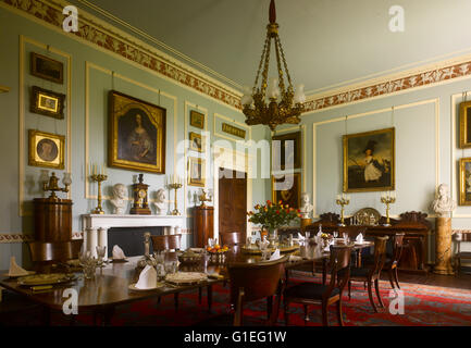 Cairness House, Fraserburgh, Aberdeenshire, Scozia. Sala da pranzo con tavolo pronto per il servizio e ritratti sulla parete. Foto Stock