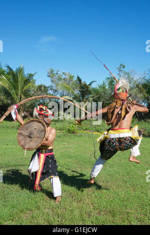 Due Danzatori tribali di eseguire warrior battaglia in costume con armi tradizionali Flores Indonesia Foto Stock