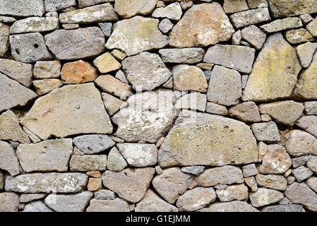 Antico muro di pietre costruita con blocchi di trachite e tufo. Consistenza Foto Stock
