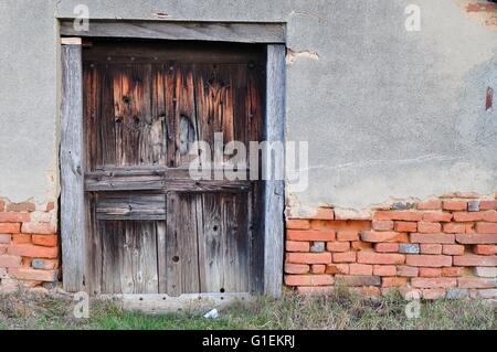 Vecchia casa abbandonata con porta di legno Foto Stock