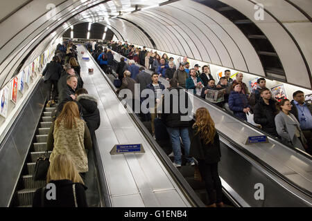 Pendolari che viaggiano fino alle scale mobili a Holborn tube station, Londra Foto Stock