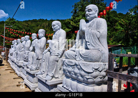 Molti nuovi statuti di Budda seduto nel parcheggio in attesa di essere installati durante il Capodanno cinese a Kek Lok Si Te Foto Stock