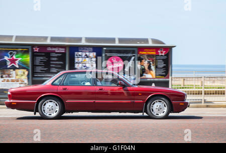 Jaguar XJS classic in movimento essendo guidato lungo il lungomare di Blackpool, Lancashire, Regno Unito. Foto Stock