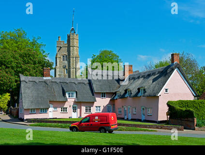 Gli ospizi di carità - e la torre della chiesa di Santa Maria - nel villaggio di Cavendish, Suffolk, Inghilterra, Regno Unito Foto Stock