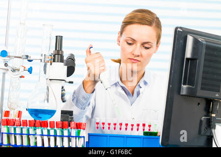 Modello rilasciato. Farmacia femmina usando una pipetta in laboratorio. Foto Stock