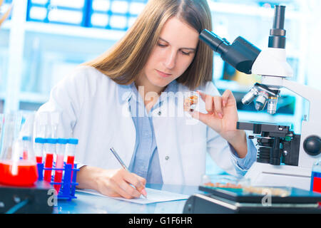 Modello rilasciato. Femmina tecnico di laboratorio azienda campioni alimentari per allergie test in laboratorio. Foto Stock