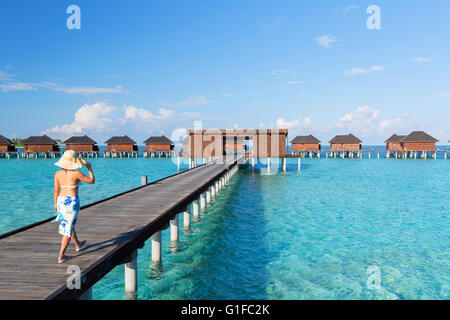 Donna presso le Ville Overwater a Olhuveli Beach and Spa Resort South Male Atoll, Kaafu Atoll, Maldive Foto Stock