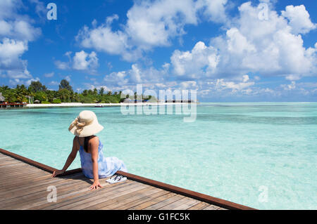 Donna sul molo Olhuveli Beach and Spa Resort South Male Atoll, Kaafu Atoll, Maldive Foto Stock