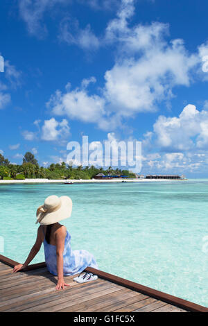 Donna sul molo Olhuveli Beach and Spa Resort South Male Atoll, Kaafu Atoll, Maldive Foto Stock