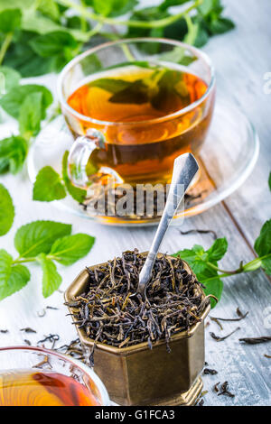 Il tè. Il tè alla menta. Il tè alle erbe. Foglia di menta. Le foglie di menta. Il tè in un bicchiere di vetro, foglie di menta, tè essiccate, fettine di lime. tè alle erbe e menta l Foto Stock