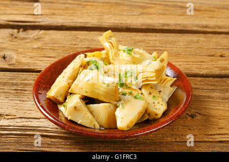 Piastra di carciofi marinati su sfondo di legno - close up Foto Stock