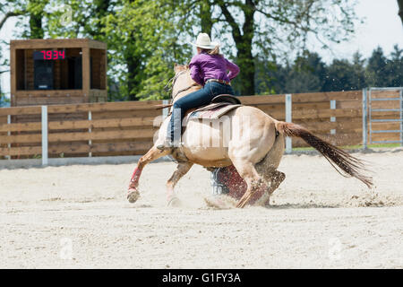 Giovani cowgirl con hat in sella ad un bellissimo cavallo di vernice in un Barrel racing evento in un rodeo in Mitrov, Repubblica Ceca Foto Stock