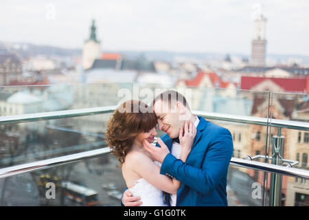 Elegante e lussuoso sposa e lo sposo elegante andando per baciare con tenerezza sullo sfondo della vecchia città di Leopoli Foto Stock