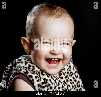 Felice di ridere un anno vecchio baby, isolato su sfondo nero Foto Stock