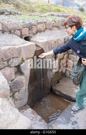 Tourist esplorando l'Inca sentieri che portano alle rovine di Pisac, Valle Sacra, importante meta di viaggio nella regione di Cusco, Perù. Foto Stock