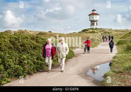 Persone che camminano in dune e water tower dell est isola Frisone Langeoog, Bassa Sassonia, Germania Foto Stock