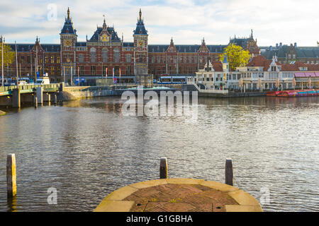 Amsterdam, Paesi Bassi - 13 Aprile 2016: il punto di vista della stazione centrale di Amsterdam con il canale nei Paesi Bassi. Foto Stock