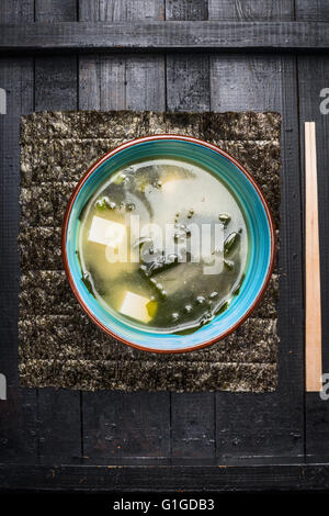 La zuppa di miso in vaso blu scuro su sfondo rustico, vista dall'alto Foto Stock