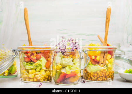 Vari tipi di insalate in vasetti per pulire take away mangiare su sfondo chiaro, vicino. Uno stile di vita sano o dieta food concept Foto Stock