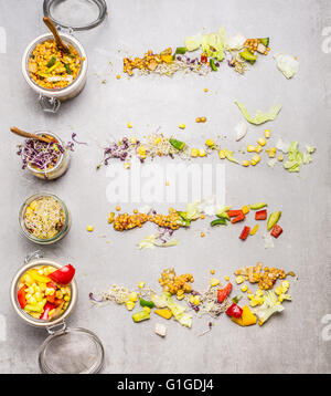 Insalate in vasi e gli ingredienti sulla pietra di luce sullo sfondo, vista dall'alto. Uno stile di vita sano o dieta food concept Foto Stock